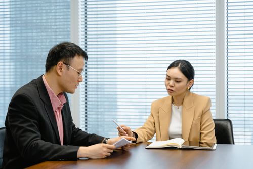 Free Two business professionals engaged in a collaborative meeting in a modern office setting. Stock Photo