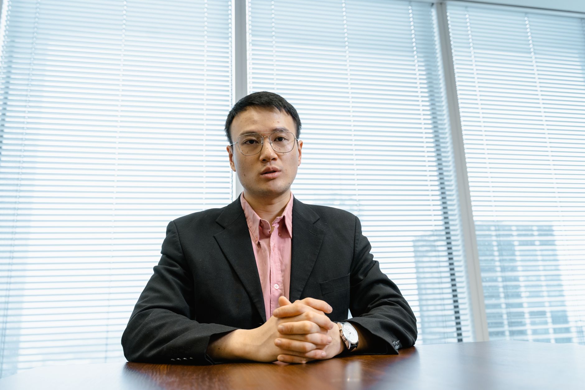 Businessman in a suit poised at his desk, exuding leadership in a modern office setting.