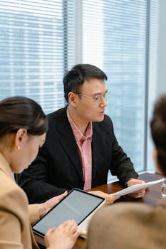 Professional team in a modern office discussing business strategies around a table.