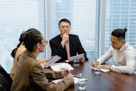 People Sitting by the Table with Glasses of Water