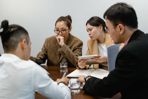 Free Professional team engaged in a brainstorming session in a modern office setting. Stock Photo