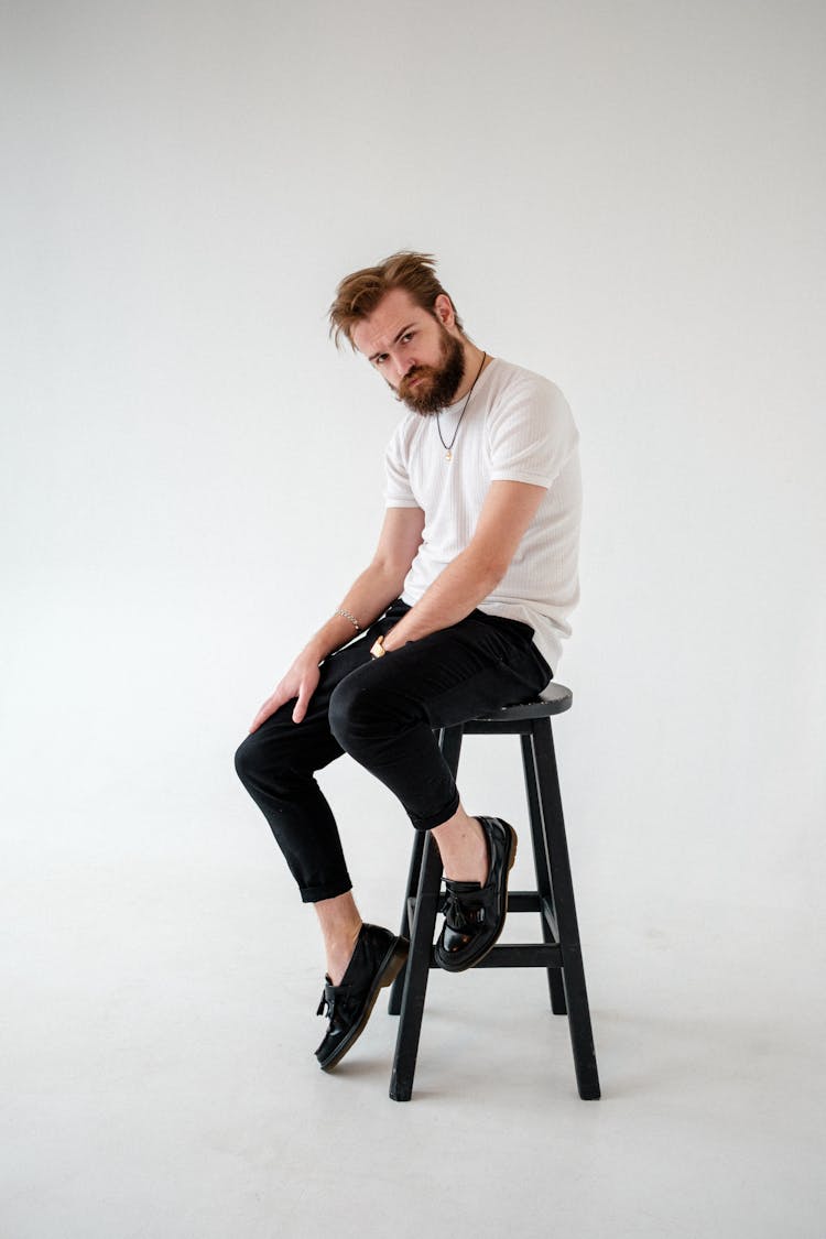 Brutal Man In Trendy Wear On Stool