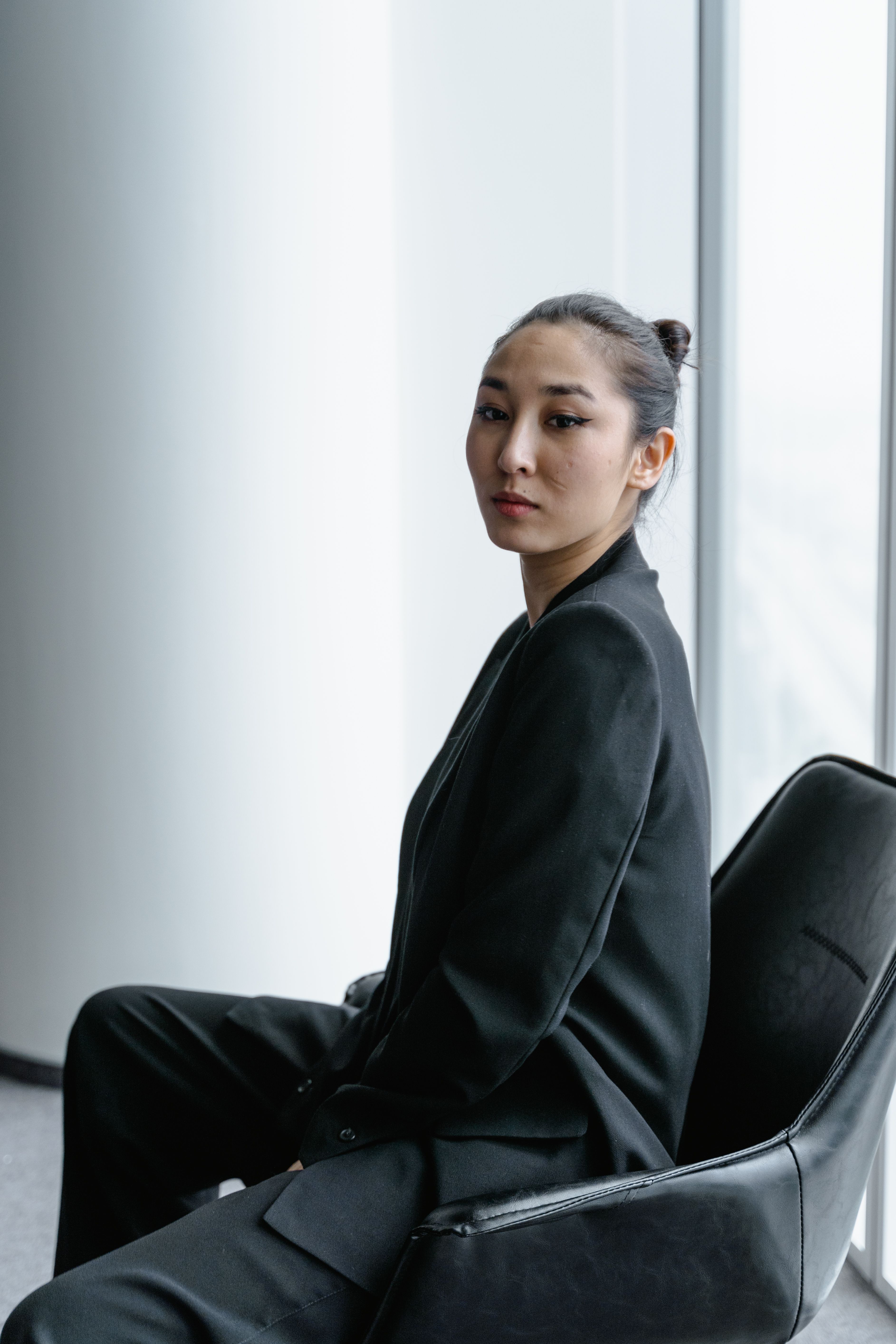A Woman Wearing a Black Blazer Sitting on a Chair · Free Stock Photo