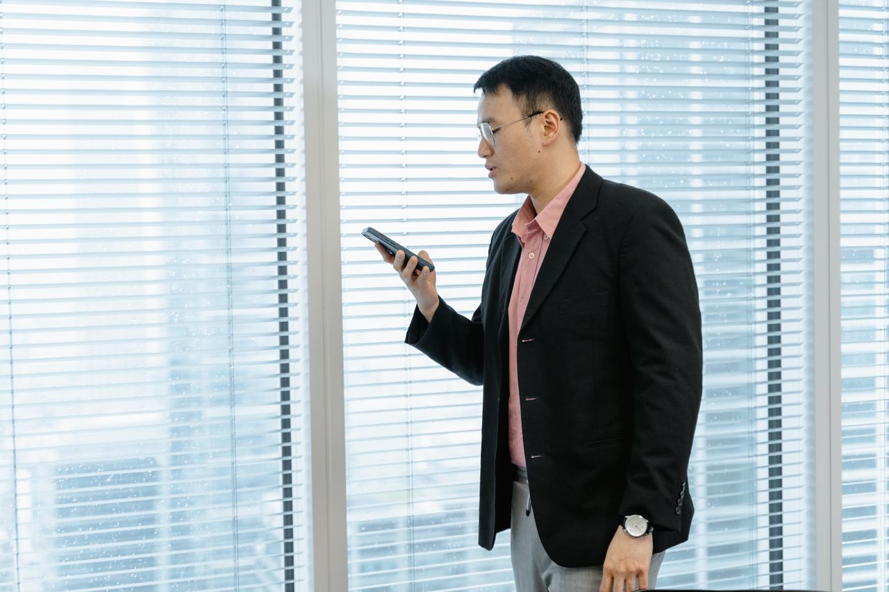 Doanh nhân gọi điện bên cửa sổ văn phòng