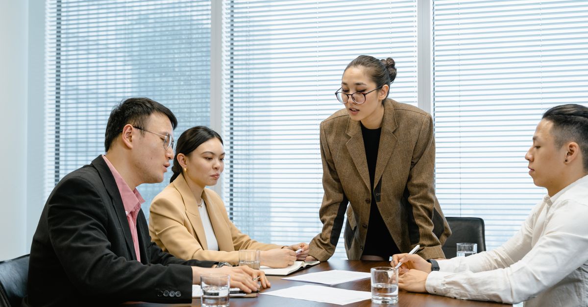 Business team engaged in a thoughtful meeting around a table in a modern conference room.