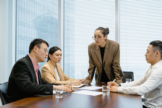 Business team engaged in a thoughtful meeting around a table in a modern conference room.