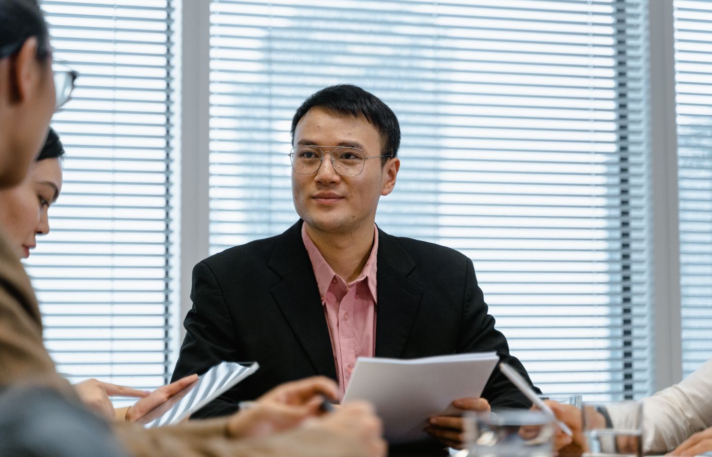 Asian businessman leading a meeting in a modern office setting, fostering collaboration and innovation.