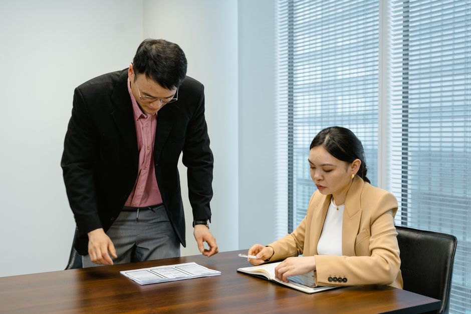 Professional colleagues in a business meeting reviewing documents and taking notes.