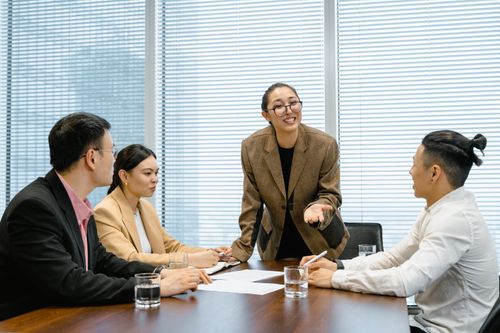 Free Business team engaged in a lively discussion during a corporate meeting. Stock Photo