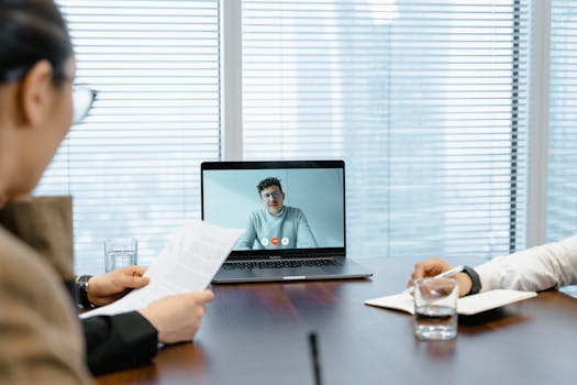Diverse team in a meeting with remote participant on video call.