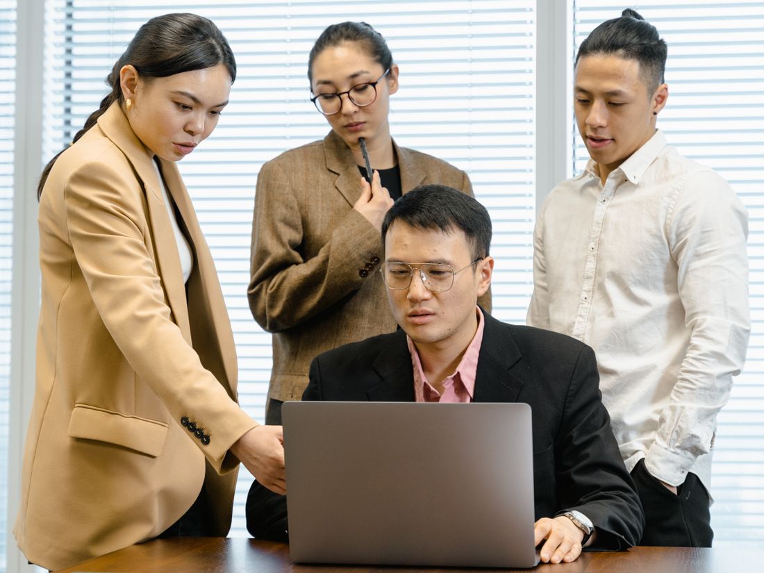 Learners looking at a laptop together