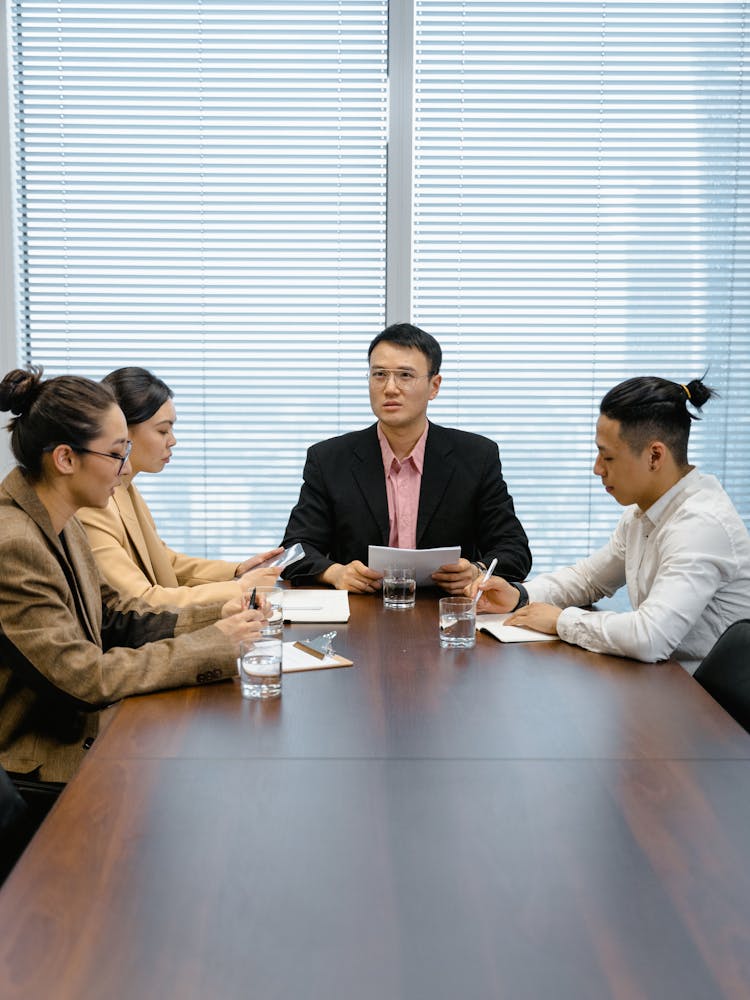 Colleagues Listening To Boss On Work Meeting