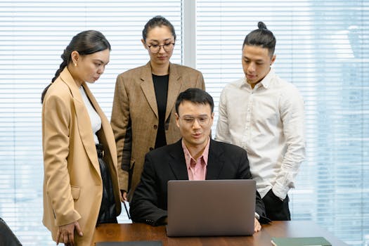 A diverse group of professionals collaborating on a project in a modern office setting.