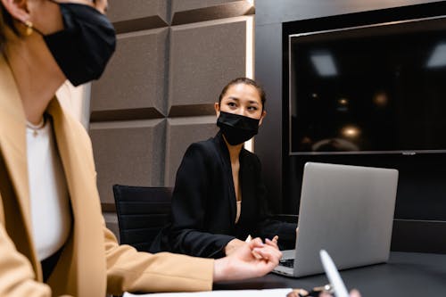 Woman in Black Face Mask Looking at Woman Beside Her
