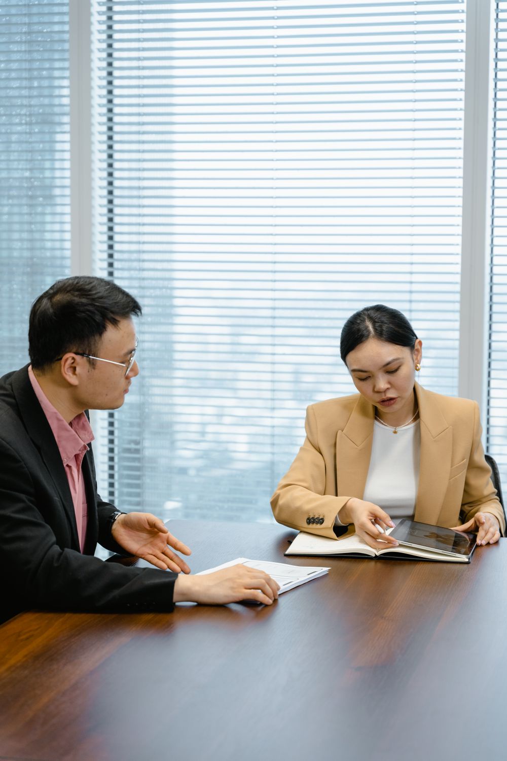 담당자와 기업 대표가 마주 앉아 서류를 보며 1:1 상담하는 장면