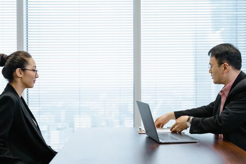 Free Two professionals engage in a job interview in a modern office. Business attire and corporate environment enhance the scene. Stock Photo