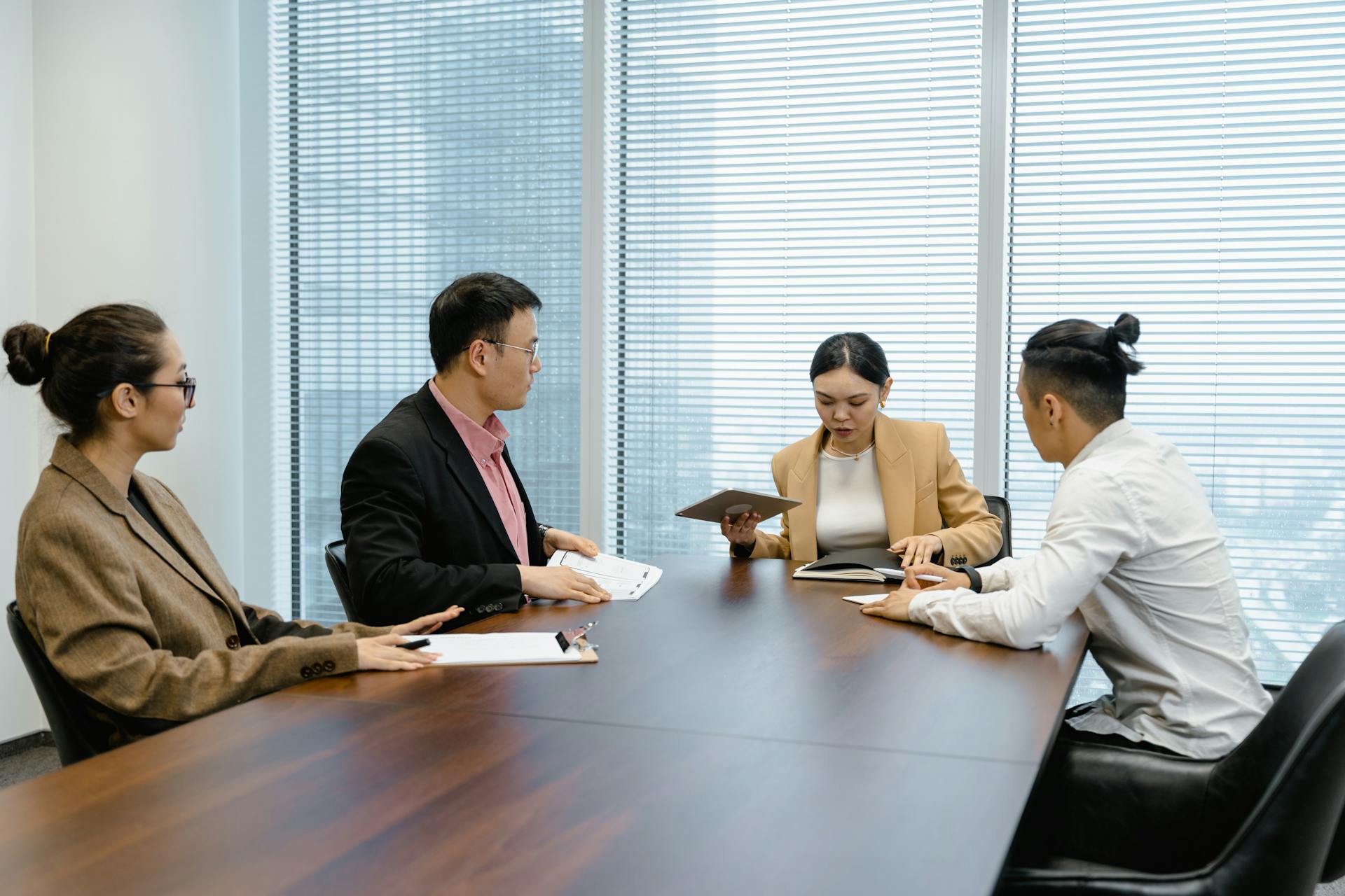 A diverse group of professionals in a boardroom meeting, discussing strategies.