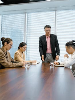 Professional team engaged in a meeting around a polished wooden table in a modern office.