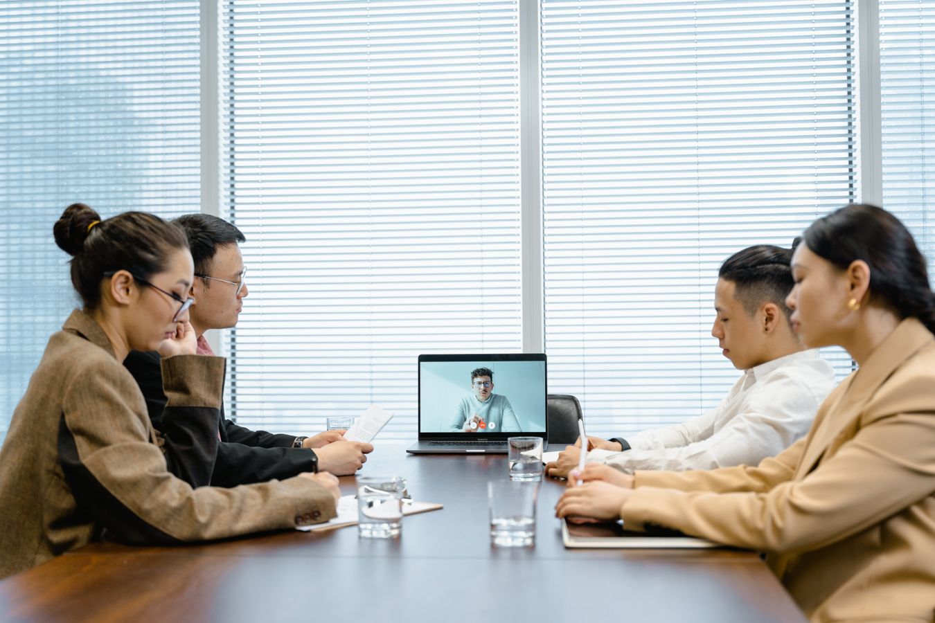 Professionals participating in a virtual business meeting around a conference table