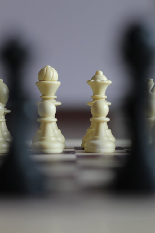 Free Closeup of chessboard with white figures bishop and queen and row of pawns Stock Photo