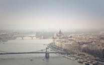 从空中俯瞰布达佩斯，多瑙河、标志性桥梁和灯光柔和的议会大楼尽收眼底