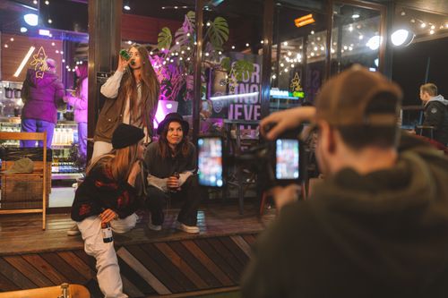 Free Group of friends enjoying nightlife, wearing trendy streetwear, captured candidly outside a bar. Stock Photo