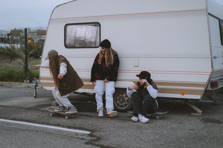 Girls With Skateboards Near Van On Parking Lot