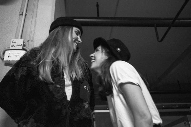 Grayscale Photo Of Two Girls Laughing Together