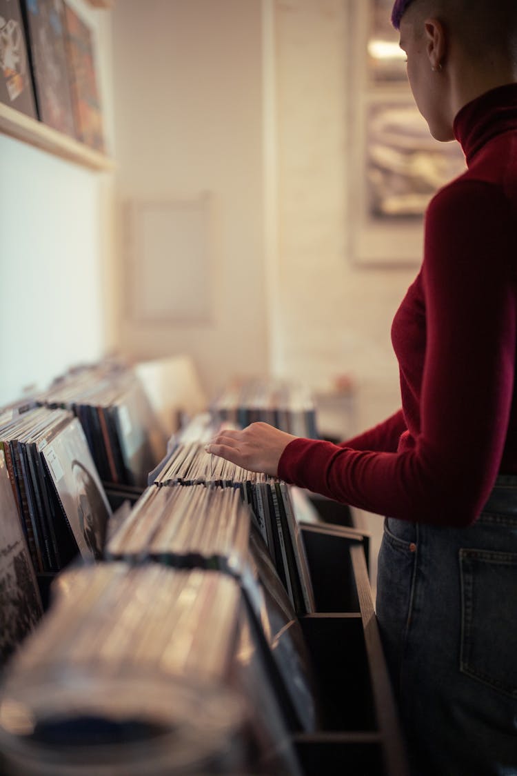 Person Standing In Front Of Old Vinyl Records