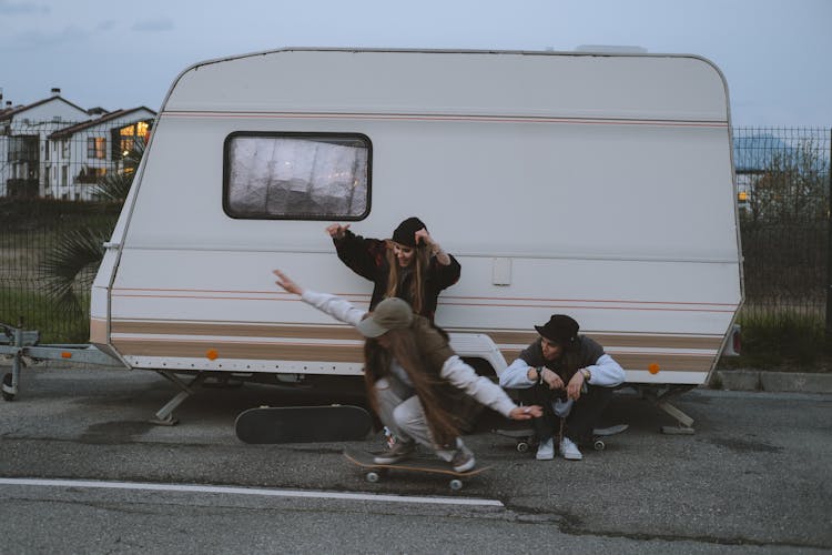 Girls With Skateboards Near Van On Parking Lot