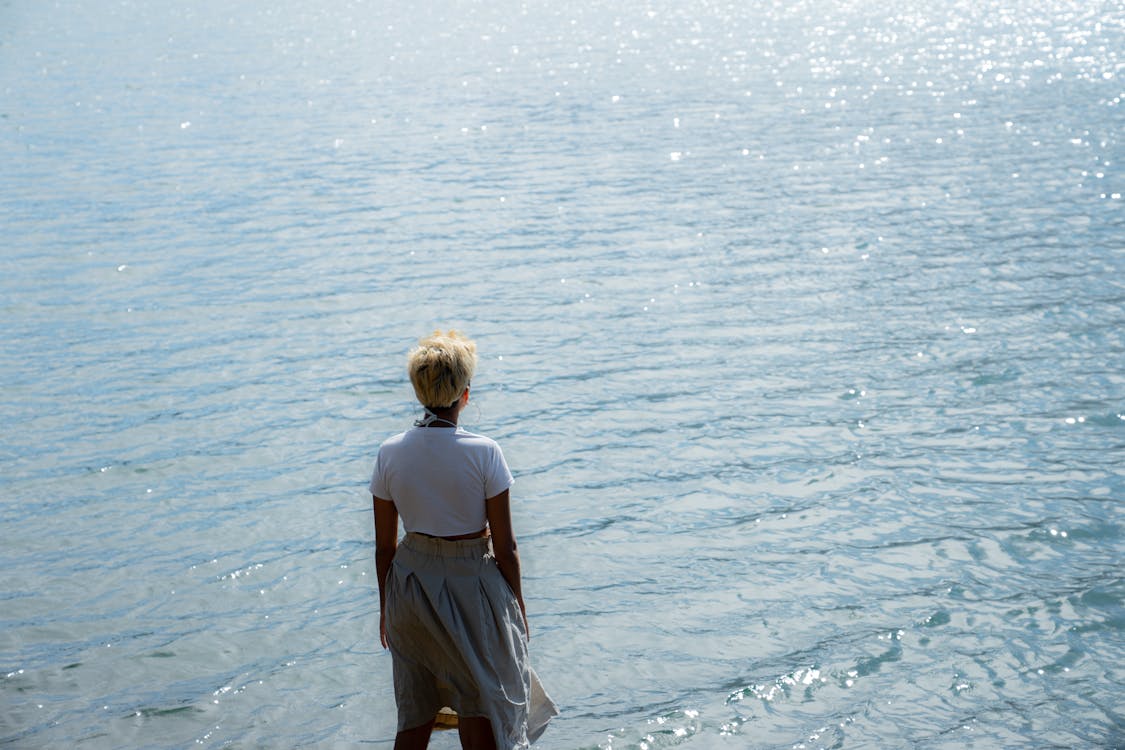 Woman in White Dress Standing on Sea Shore · Free Stock Photo