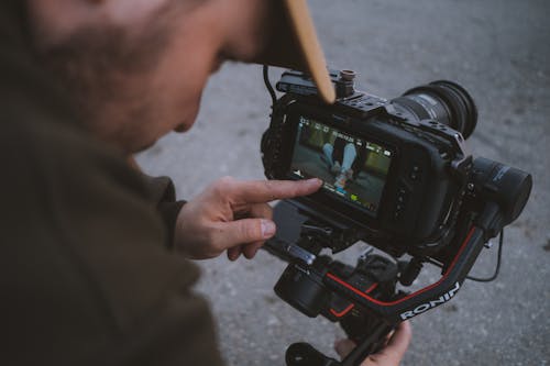 Základová fotografie zdarma na téma dslr fotoaparát, kameraman, přes výstřel přes rameno