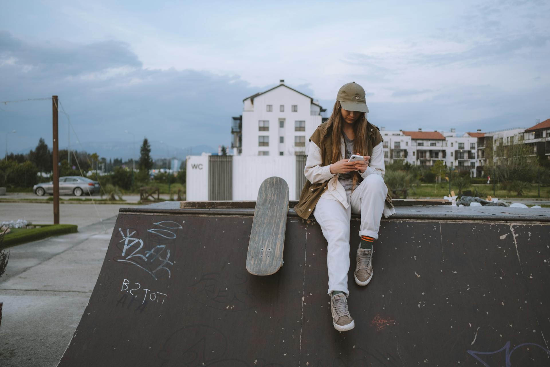 Woman with Skateboard Sitting on Ramp