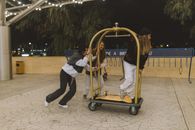 Friends Playing with a Hotel Luggage Cart