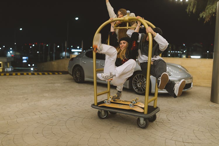 A Group Of Women Playing With A Hotel Trolley