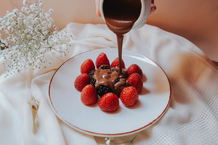 Pouring Of Chocolate Ganache On Berries