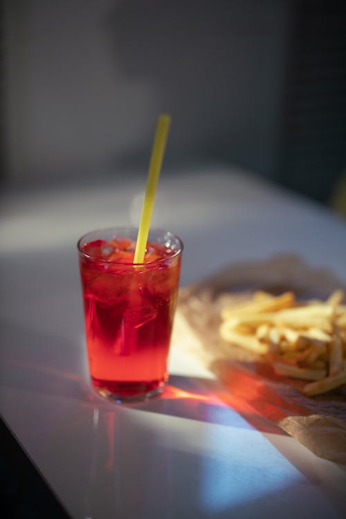  Drink with Straw and French Fries on White table