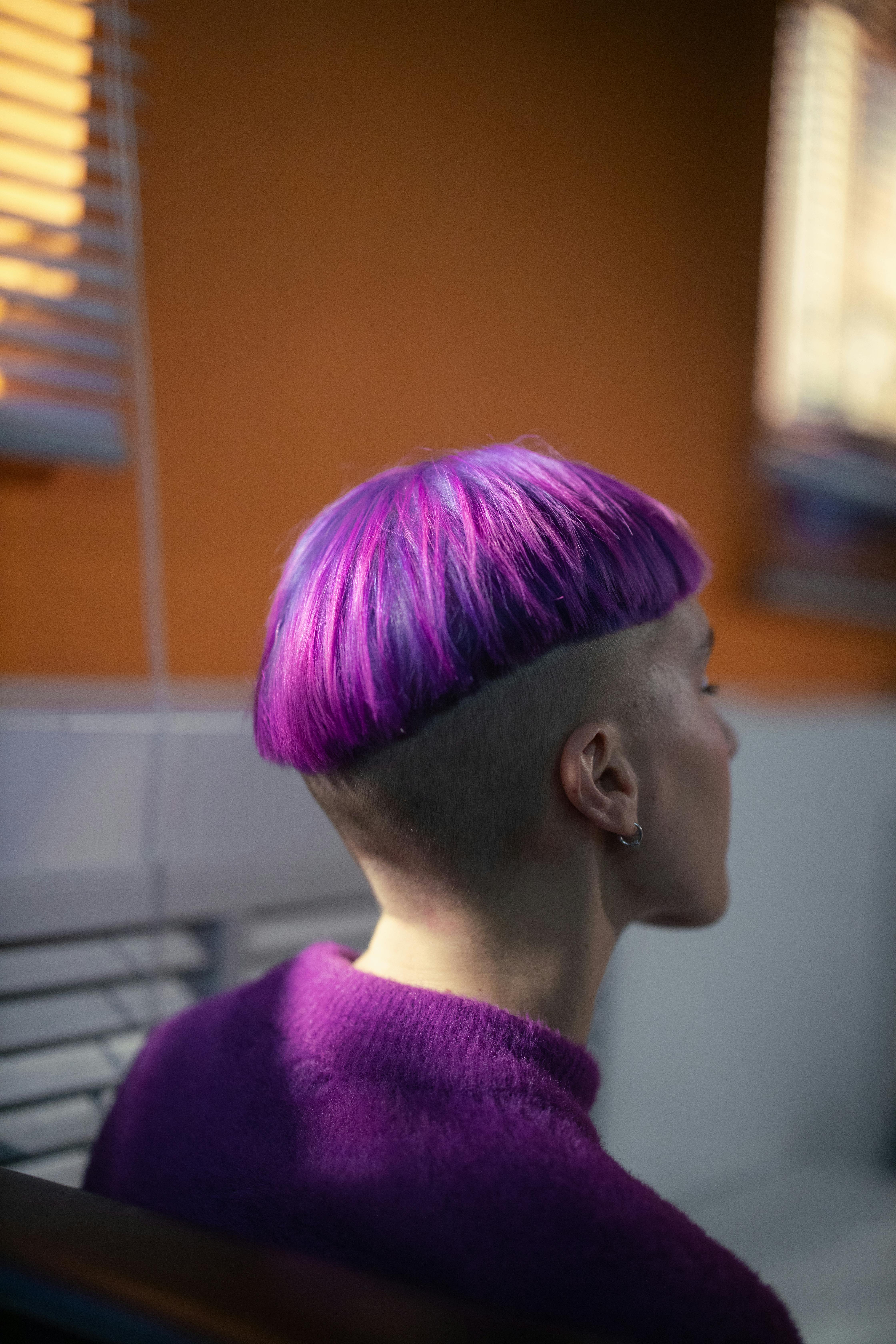 Stylish back view of short purple haircut, soft focus indoors.