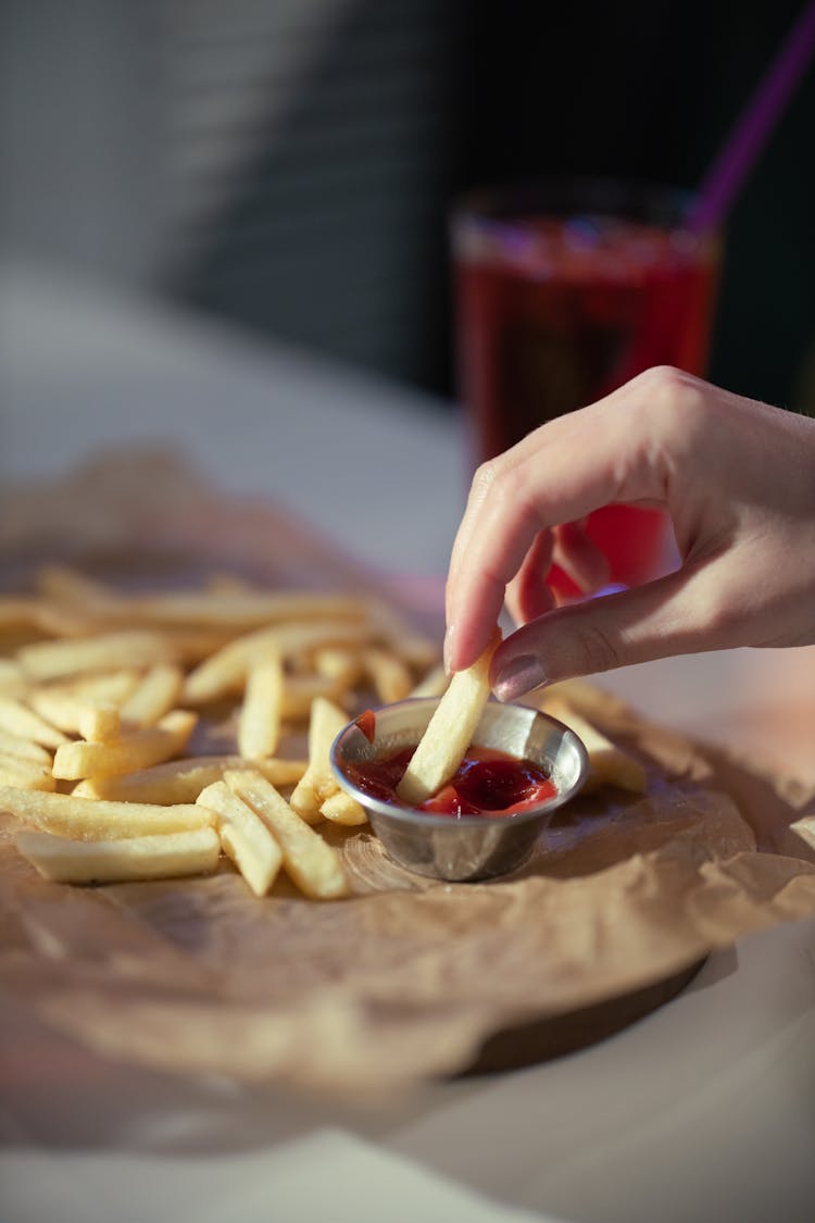 Close Up Photo Of Person Dipping A French Fry