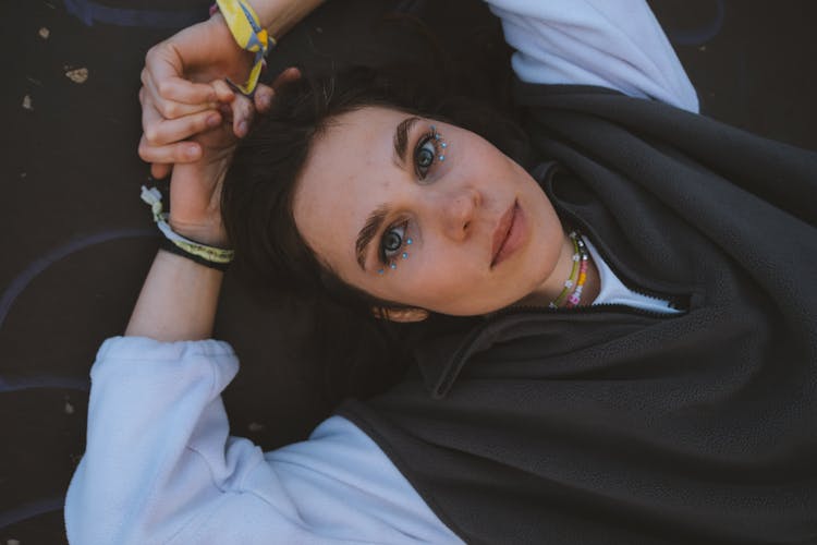 A Woman Wearing Jacket With Gemstones Under The Eyes