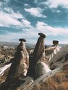 Historical stony formations located in arid area against blue sky with clouds on summer day in highlands of Cappadocia in Turkey