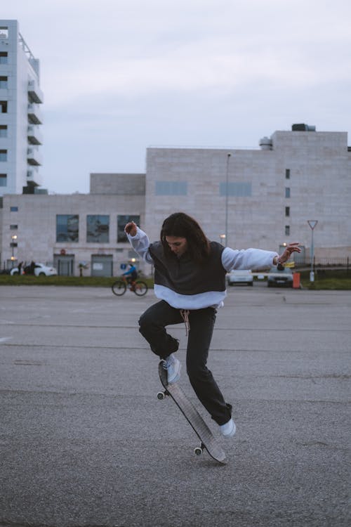 Free A Woman Riding a Skateboard on the Concrete Pavement Stock Photo