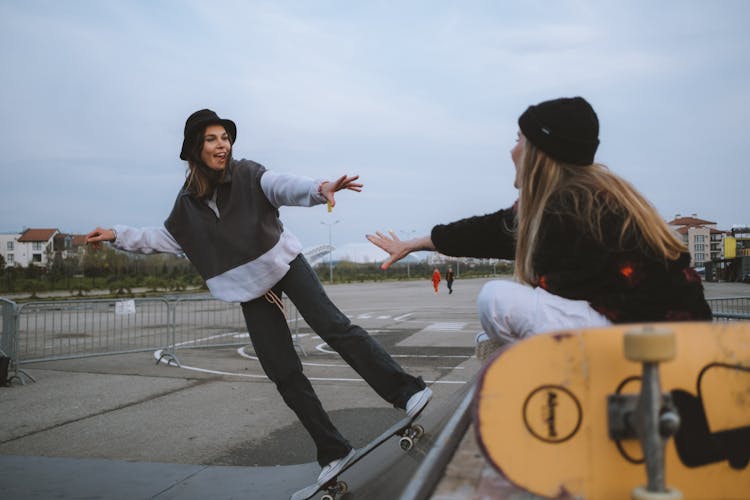 Skateboarders Reaching For Each Other