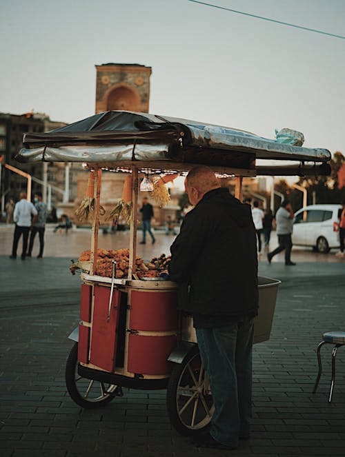 Free Man in Black Jacket Selling Corn Cob in the Food Cart Stock Photo