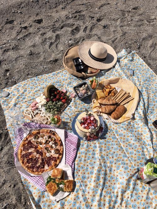 Free A vibrant beach picnic with assorted snacks and pizza on a sunny day in Turkey. Stock Photo