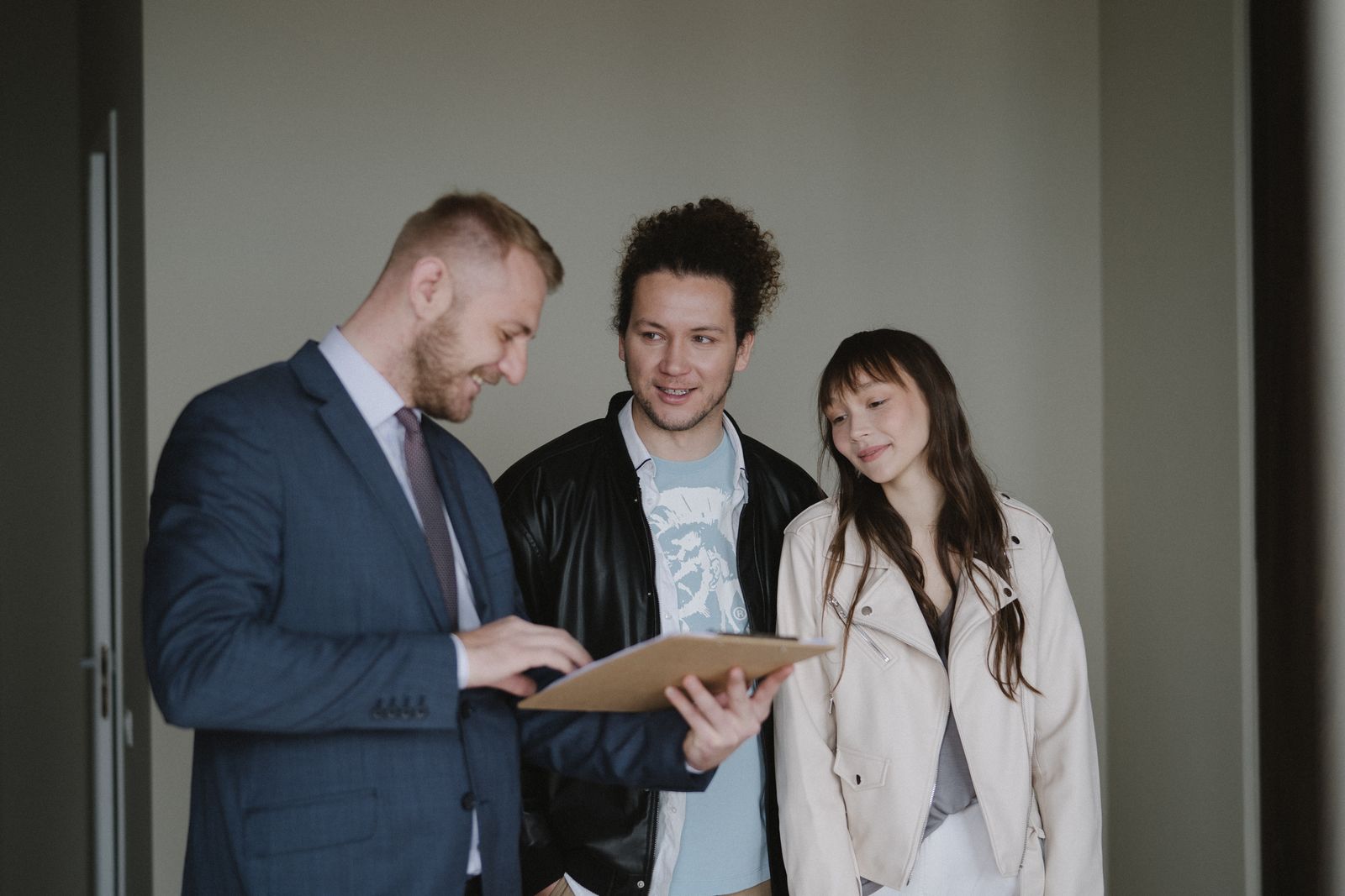 Free Happy couple meeting with a real estate agent discussing paperwork indoors. Stock Photo