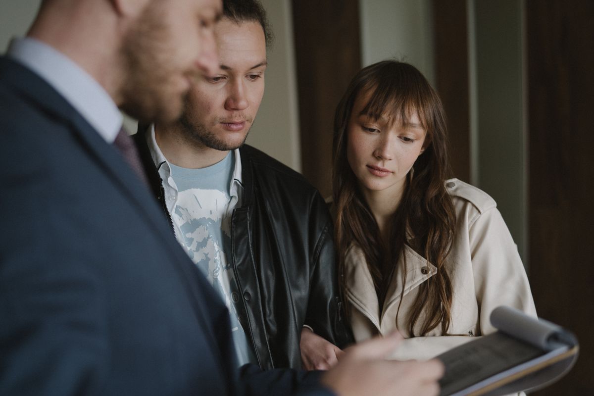 A homebuyer couple reviewing documents with a trusted real estate professional