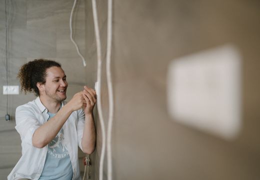 Electrician adjusting an electrical outlet indoors