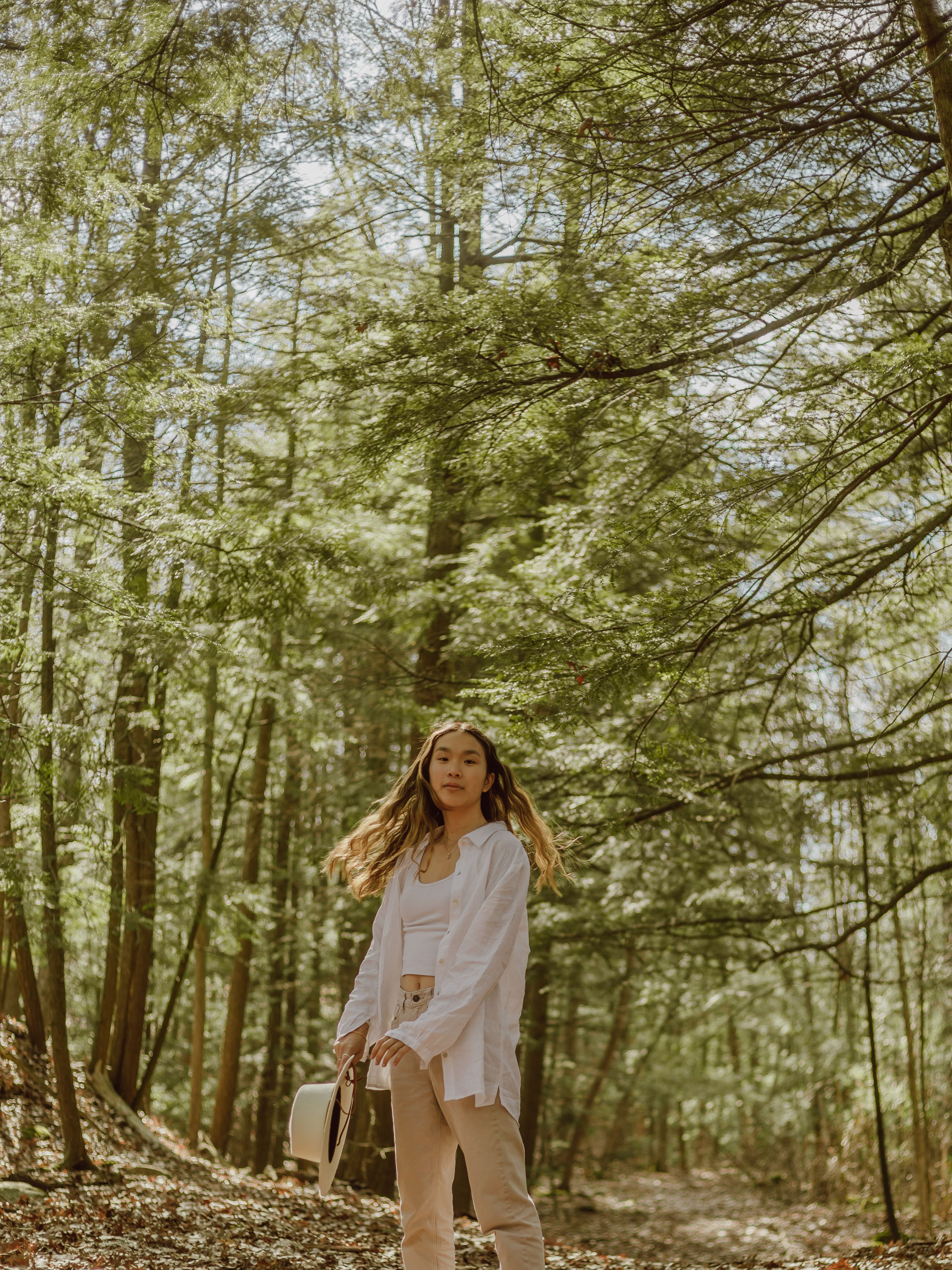 A Woman in White Dress Shirt Standing Near Trees · Free Stock Photo