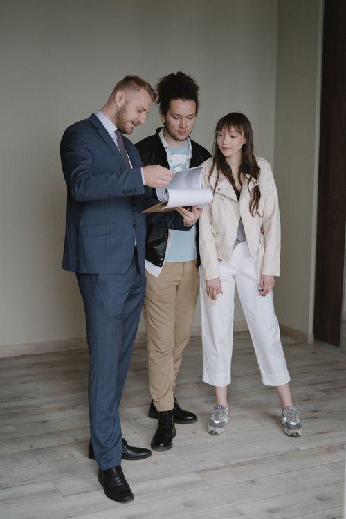 Couple examinant les documents de son futur logement avec un professionnel